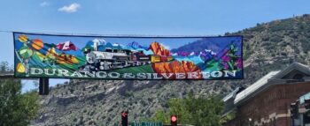 A colorful banner shows a train and mountains, reading "Durango & Silverton" above a street with a 9th Street sign.