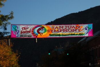 Banner across street advertising San Juan Symphony at Community Concert Hall, with a phone number and colorful graphics.